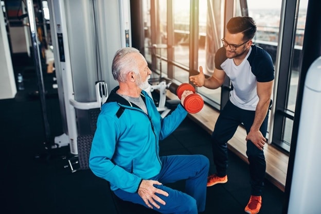 physical therapist helping a patient strengthen his arm muscles