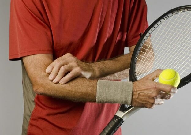 Tennis player holding his painful elbow