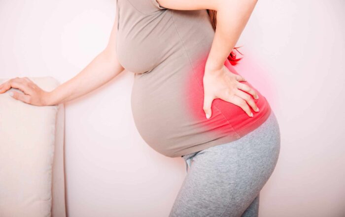 woman with lower back pain while being pregnant
